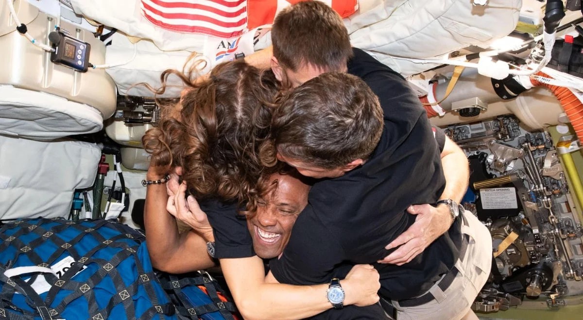 astronauții Artemis II îmbrățișându-se în spațiu